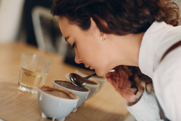 Een vrouw die kopjes koffie aan het testen is